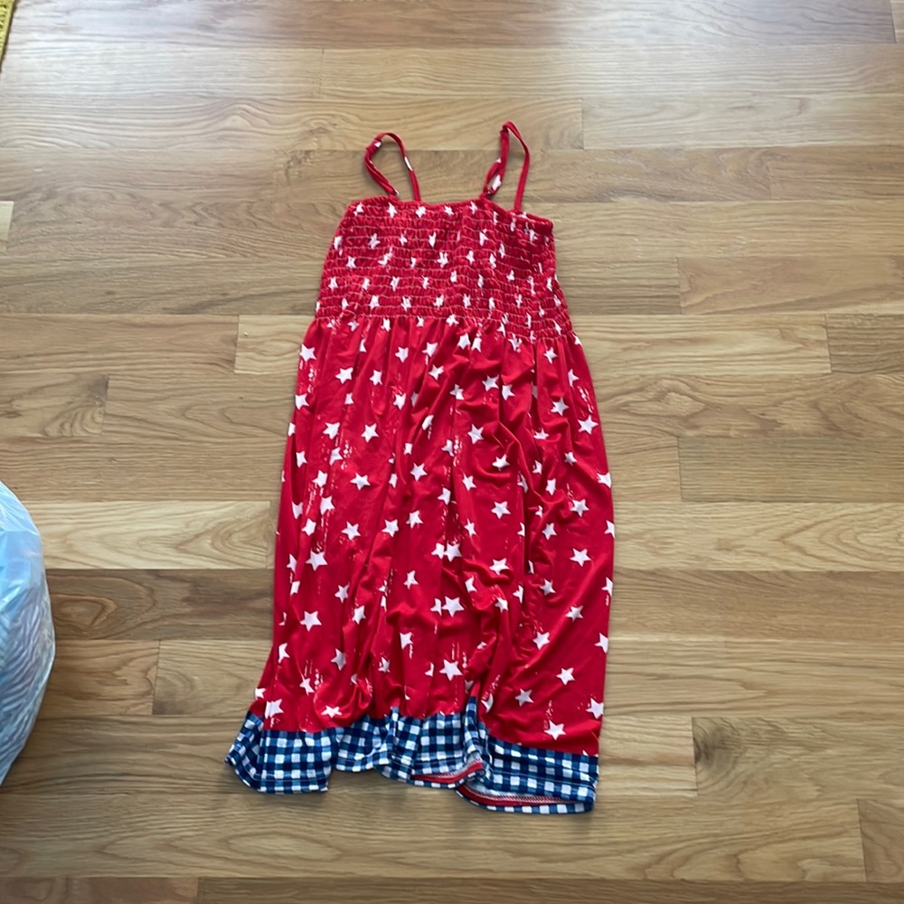 red dress with white stars and blue and white squares on bottom. silky material